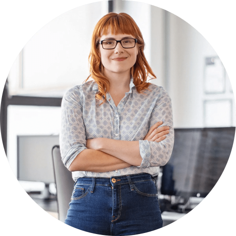 Woman standing confidently with arms crossed in an office space